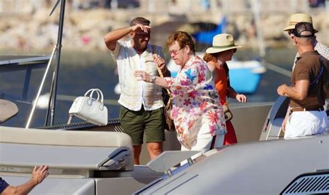 elton john 75 clutches onto entourage as he struggles to board yacht with husband david
