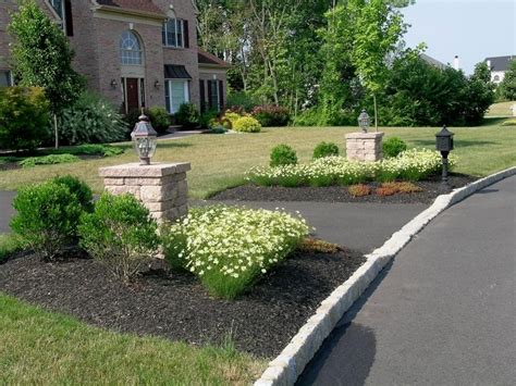 The Landscaping Surrounding The Pillars At The Driveway Entrance