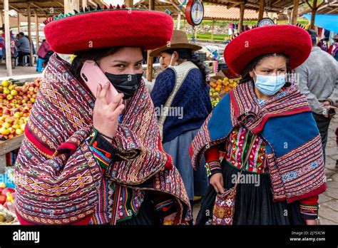 Young Indigenous Quechua Women Using Mobile Phones At The Famous Sunday