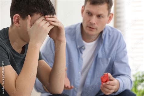 stockfoto father talking with his teenage son about contraception at home sex education concept