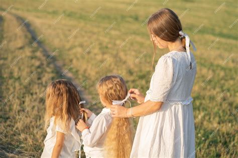 Premium Photo A Gentle Mother With Two Daughters In Nature Mom Braids