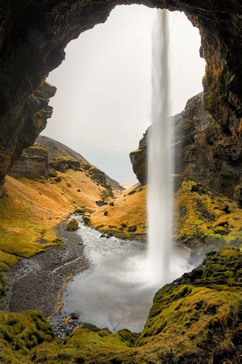 A Waterfall Is Coming Out Of The Side Of A Cave