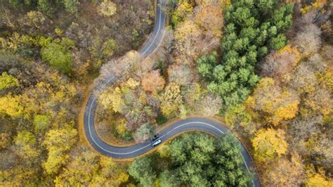 Aerial View Of Curvy Road In Forest Autumn High In Mountains Stock