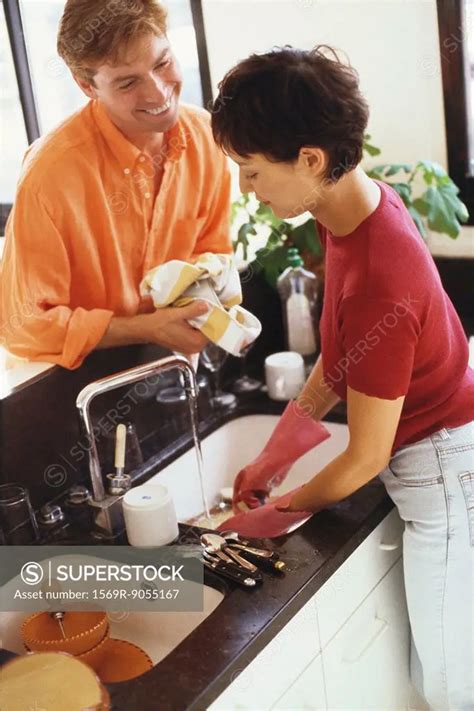 Couple Doing Dishes Together At Kitchen Sink Superstock