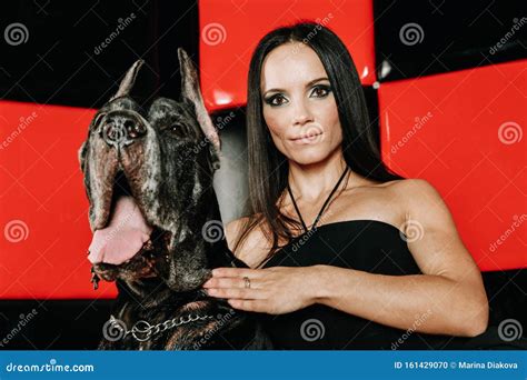 Beautiful Young Woman Posing With Her Great Dane Dog In The Studio In