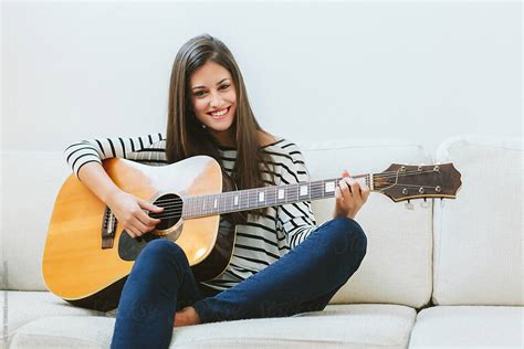 Woman Playing Guitar At Home By Stocksy Contributor Victor Torres