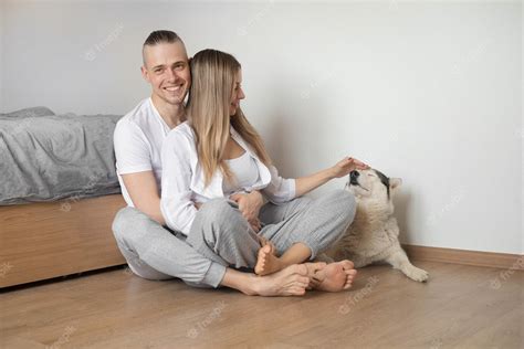 Premium Photo Couple Sitting On The Floor Petting A Dog