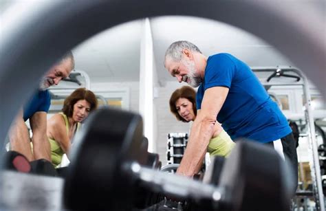 Senior Couple In Gym Working Out With Weights Stock Image Everypixel