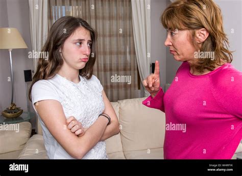 Angry Mother Scolding Daughter While Standing In Living Room At Home