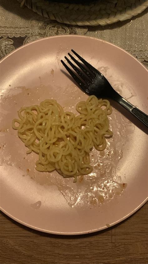 A Plate With Some Noodles On It And A Fork Next To The Plate That Is