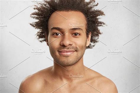 Headshot Of Shy Dark Skinned Male With Crisp Hair Smiles Broadly
