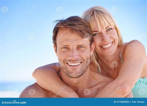 Seaside Happiness A Happy Couple Sitting On The Beach Smiling At The