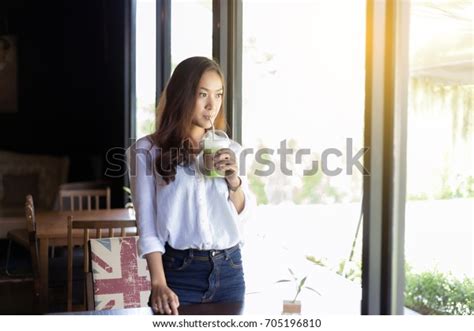 Asian Women Drinking Coffee Looking Outside Stock Photo 705196810