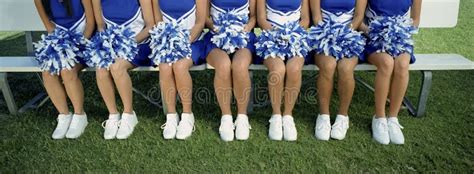 Cheerleaders Sitting With Legs Crossed At Knee On Field Stock Image