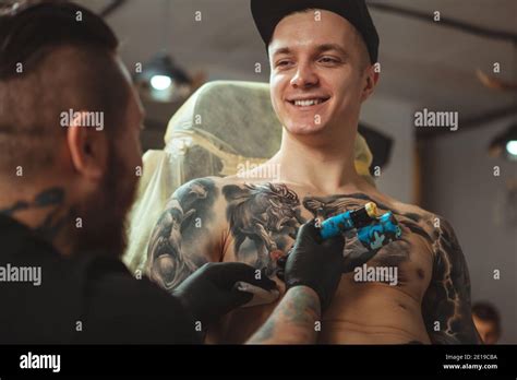 Un Joven Alegre Y Guapo Sonriendo Hablando Con Su Artista De Tatuaje Mientras Se Inked En El