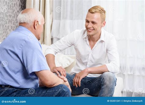 Grandfather And Grandson Sitting On Couch Together Stock Image Image