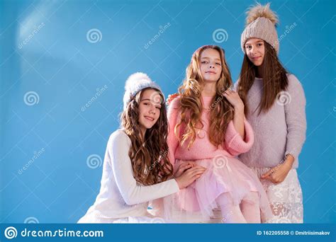 Three Beautiful Girls In Winter Hats And Warm Clothes Stock Photo
