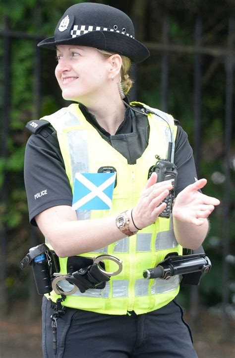 A Woman In A Police Uniform Is Holding Her Hands Out To The Side And Smiling