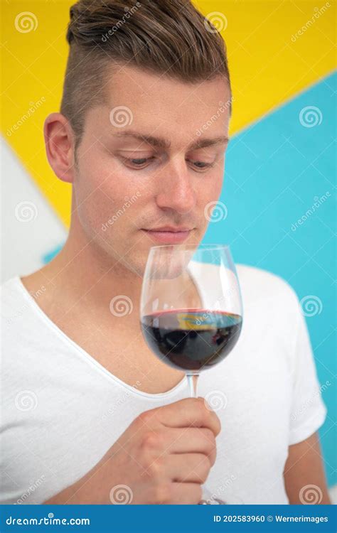 Blond Man Holding A Glass Of Red Wine On Colorful Background Stock