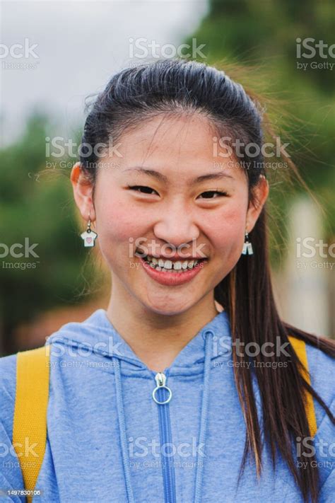 Vertical Close Up Portrait Of Cute Asian Schoolgirl Standing And Laughing At Campus Young