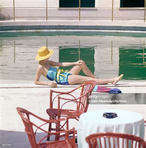 A Girl In Swimsuit And Straw Hat Sunbathing By The Swimming Pool News Photo Getty Images