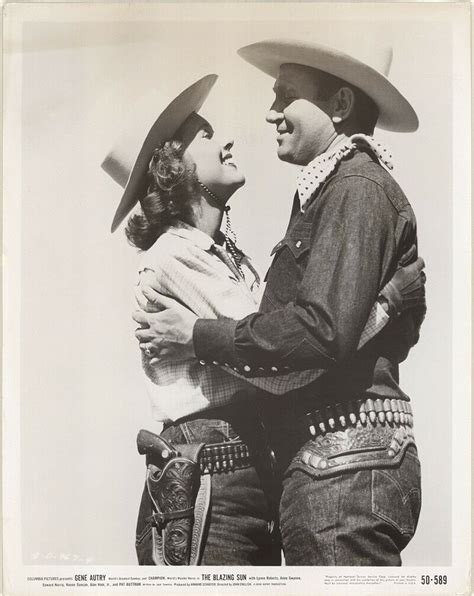 An Old Black And White Photo Of Two People In Cowboy Hats One Holding