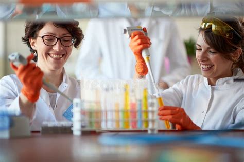 Young Female Chemistry Students Enjoy While Pipetting Colourful