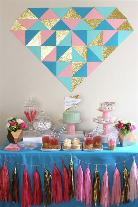 A Table Topped With Cake And Tassels Covered In Pink Blue And Gold