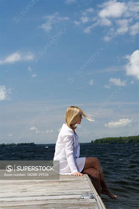 Woman Sitting On Dock Superstock
