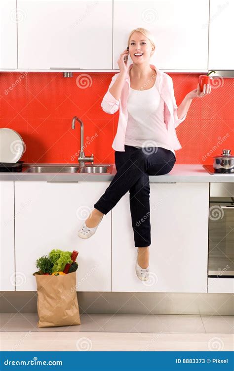 Woman Sitting On Counter In Kitchen Stock Photos Image 8883373