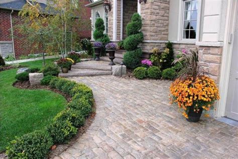 Structured Evergreen Garden Beds With Colorful Planters Front Yard