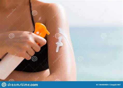 Woman Is Putting Sun Lotion On Her Shoulder At The Sea Background Stock Photo Image Of