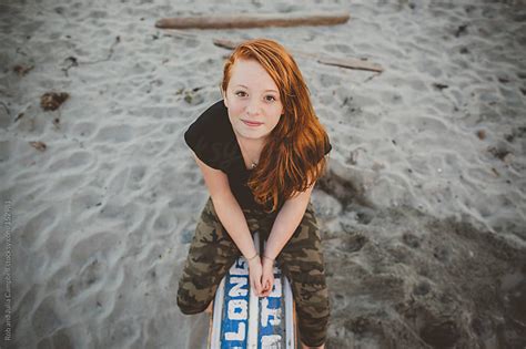 Content Portrait Of Redhead Teenage Girl Sitting At The Beach By Rob And Julia Campbell