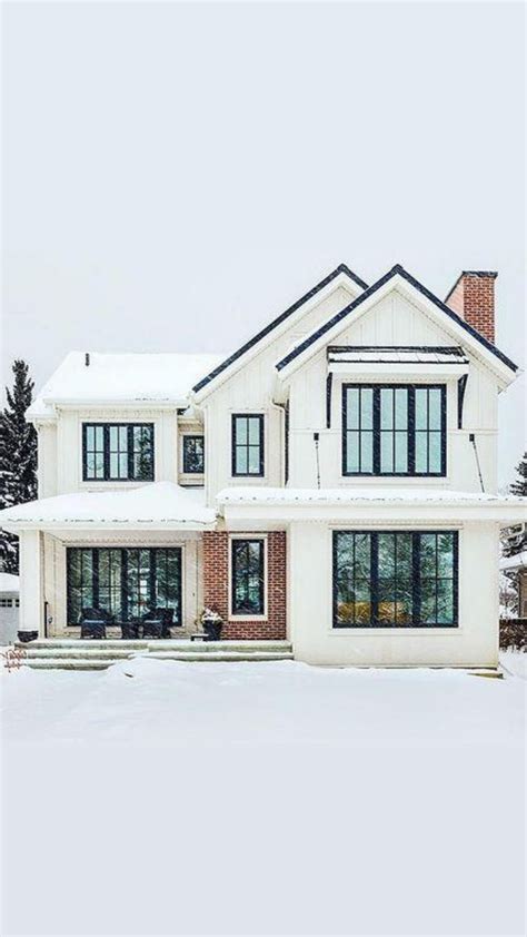 A Large White House With Lots Of Windows In The Snow