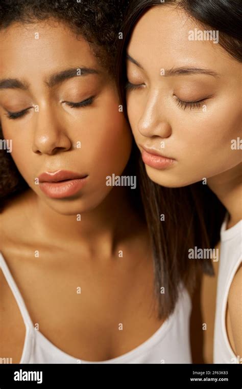 Face Closeup Of Two Beautiful Mixed Race Young Women With Perfect Glowing Skin Posing Together