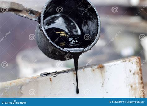 Melted Hot Black Tar From Metal Cup On Surface With Steam Stock Image