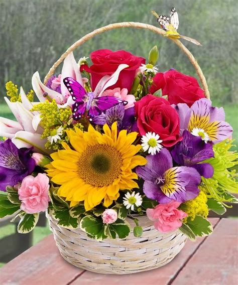 A Basket Filled With Flowers On Top Of A Wooden Table