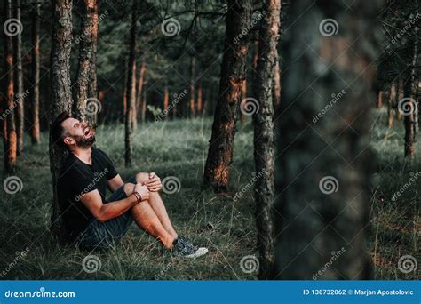 Young Depressed Man Sitting Alone In The Woods Stock Photo Image Of