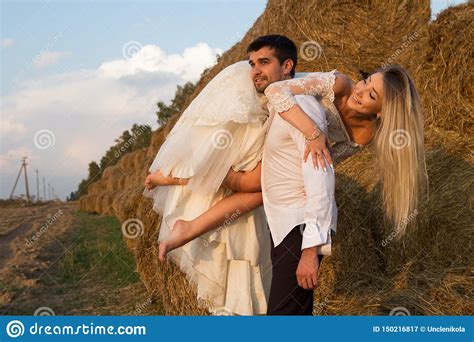 Groom Carries Bride On Shoulder Along Haystack Stock Image - Image of barefoot, hand: 150216817