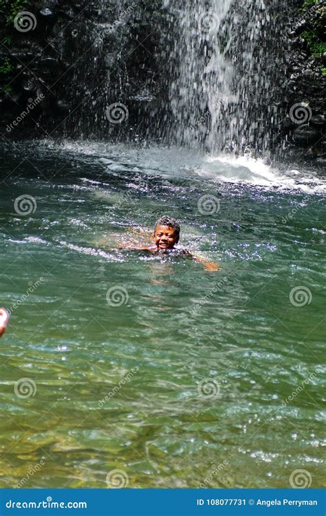 Child Playing In A Pool At The Base Of A Waterfall In Ecuador Editorial