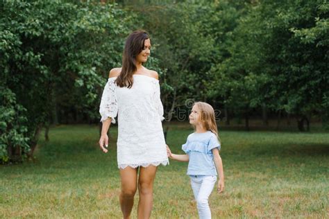 A Little Daughter Holds Her Mother S Hand Mother And Daughter Walk In