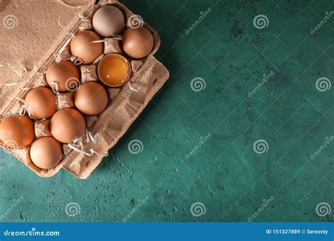 Cracked And Whole Chicken Eggs In Carton Box On Color Table Stock Image