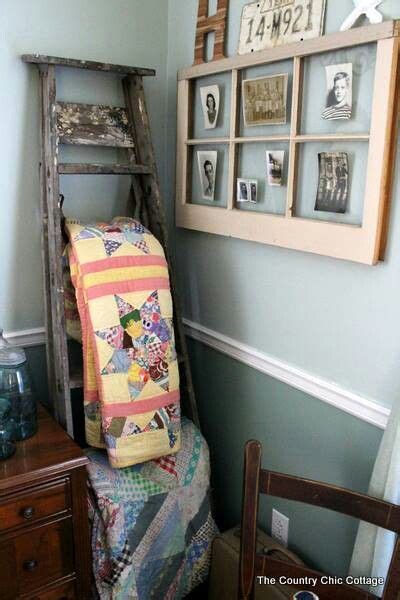 A Chair With A Quilt On It In Front Of A Ladder And Some Pictures