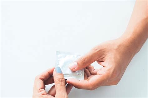 free photo condom in male hand and female hand give condom safe sex concept on white background