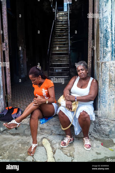 Two Cuban Women Sitting On The Stoop Of A Doorway In Havana Cuba Stock