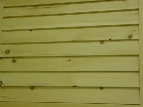 The Side Of A Yellow Building With Wood Slats