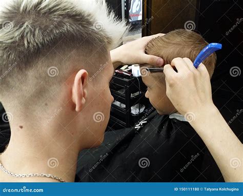 Caucasian Hairdresser With Razor Shave The Boy In The Barber Shop