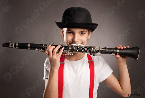 Little Girl Playing Clarinet On A Gray Background Stock Photo 1410289