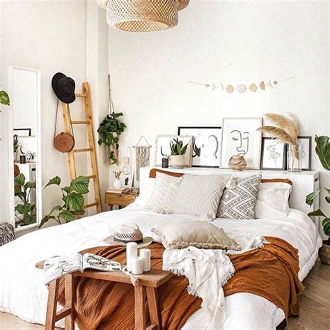 A Bedroom With White Walls And Lots Of Plants On The Bed Along With