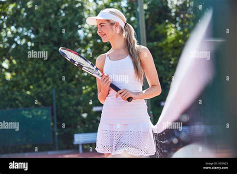 Smiling Young Female Tennis Player Holding Tennis Racket Along Sunny